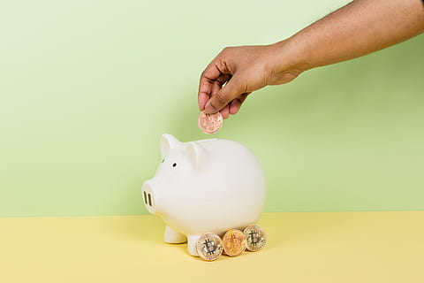 Depositing money in a piggy bank.